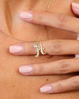 Gold necklace with an H pendant on a model's chest.