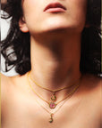 Close-up of a woman wearing gold necklaces with a visible brand logo.