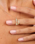 Gold necklace with a D pendant on a person's neck