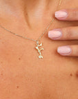 Gold necklace with a pendant worn around the neck, close-up view.