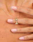 Gold necklace with a letter 'I' pendant on a person's neck