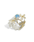 Gold and silver ring with a blue gemstone on a white background