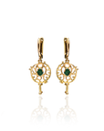 Gold earrings with green gemstones on a white background