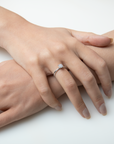 Close-up of two hands with a ring on a white background