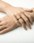 Close-up of a hand wearing a diamond ring on a white background