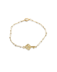 Gold bracelet with a key charm on a white background