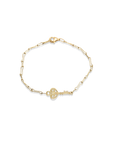 Gold bracelet with a key charm on a white background