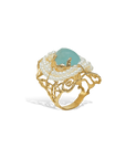 Gold ring with pearls and a green gemstone on a white background