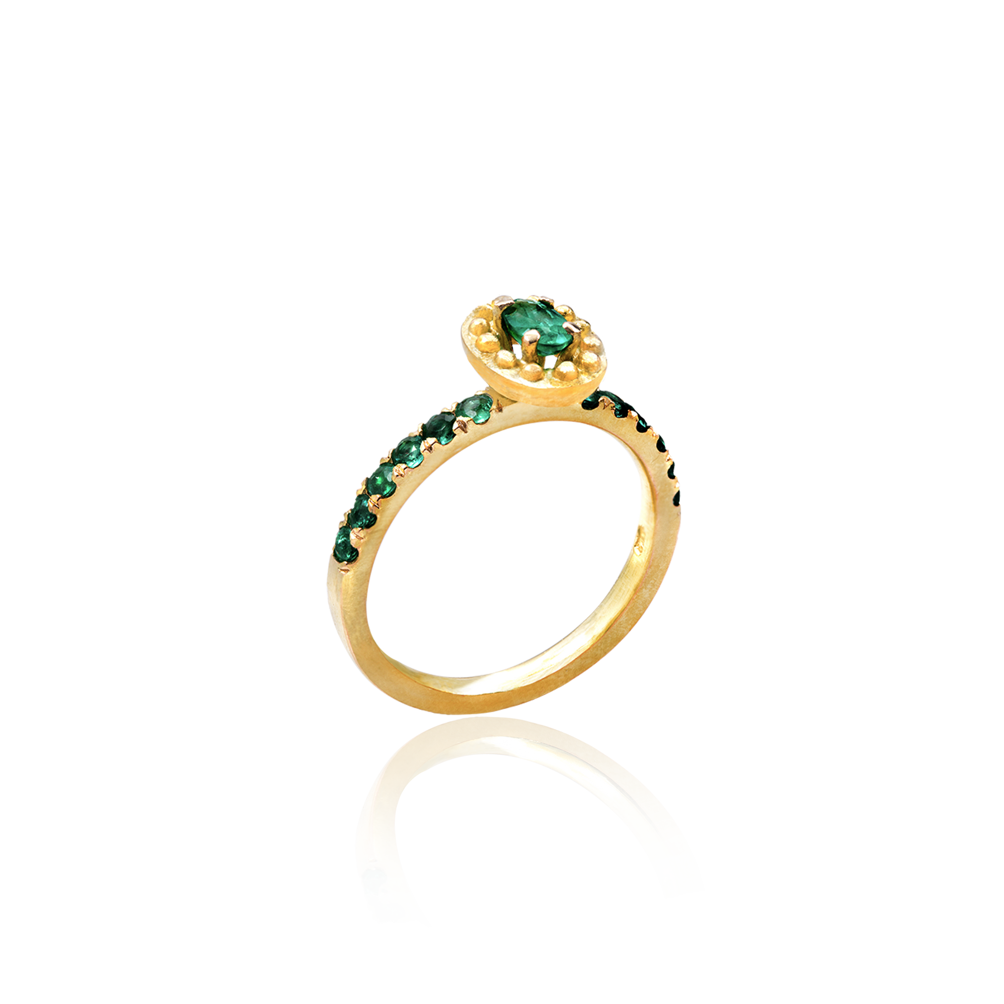 Gold ring with green gemstones on a white background