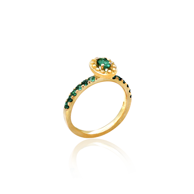 Gold ring with green gemstones on a white background