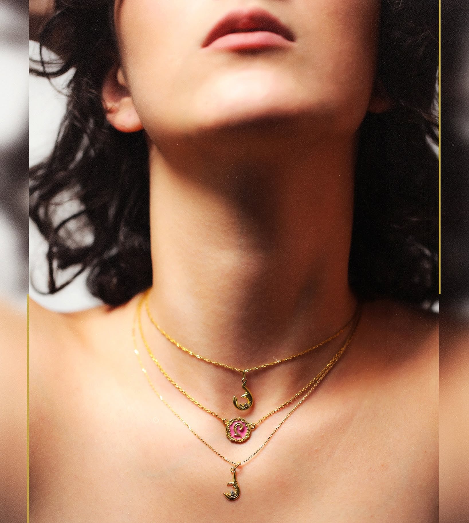 Close-up of a woman wearing gold necklaces with a visible brand logo.