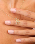 Gold necklace with an initial K pendant on a person's hand