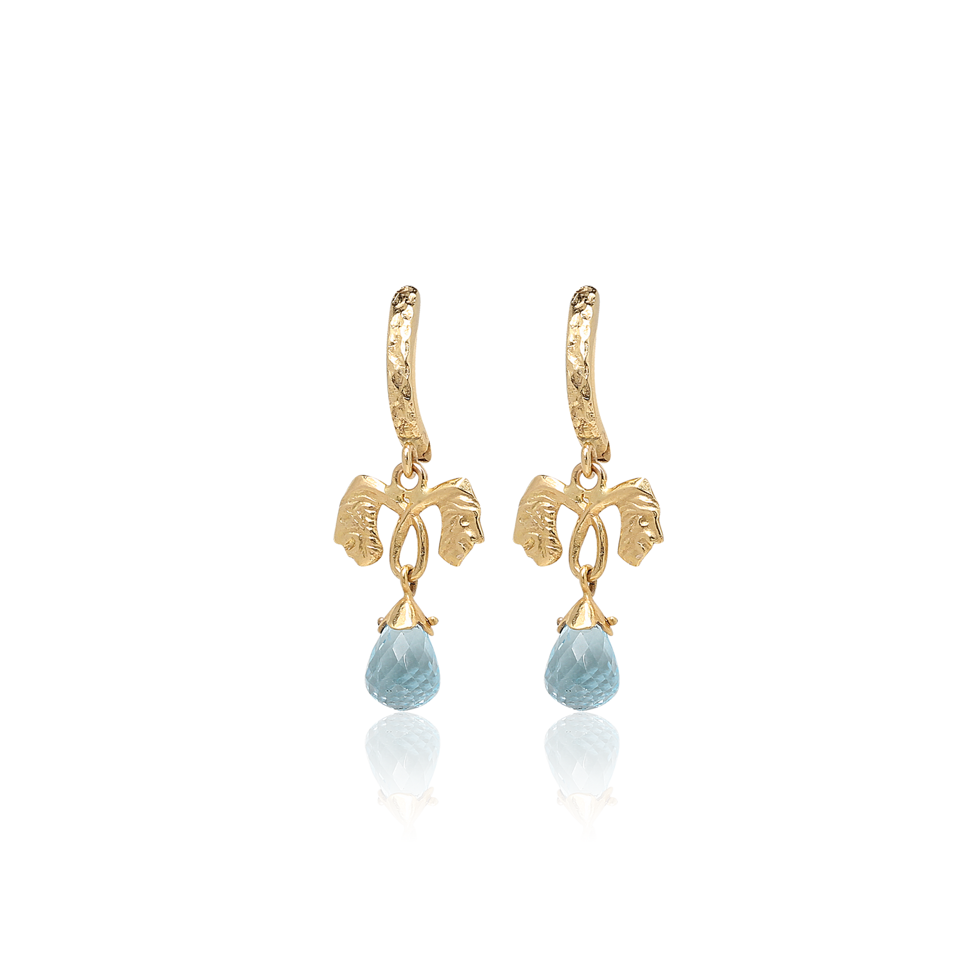 Gold earrings with blue gemstones on a white background