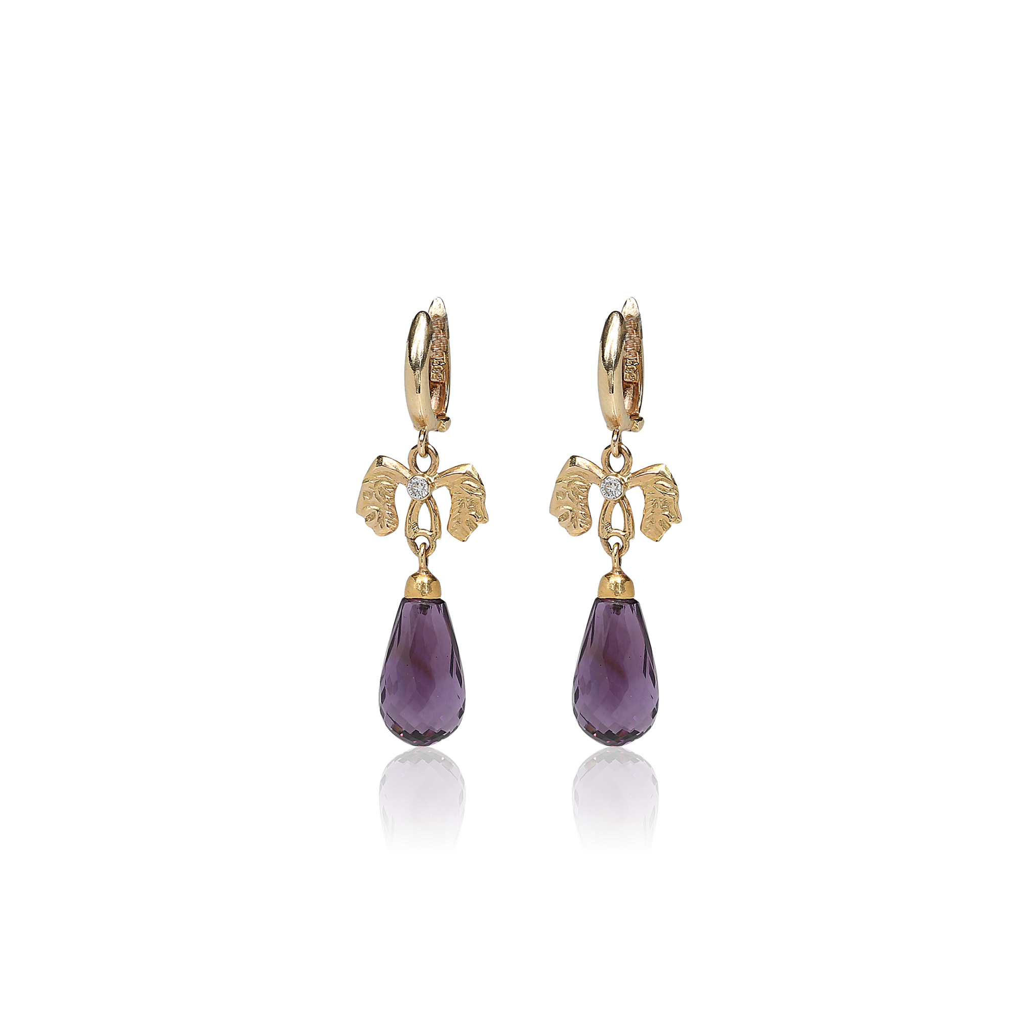 Gold earrings with purple teardrop-shaped gemstones on a white background