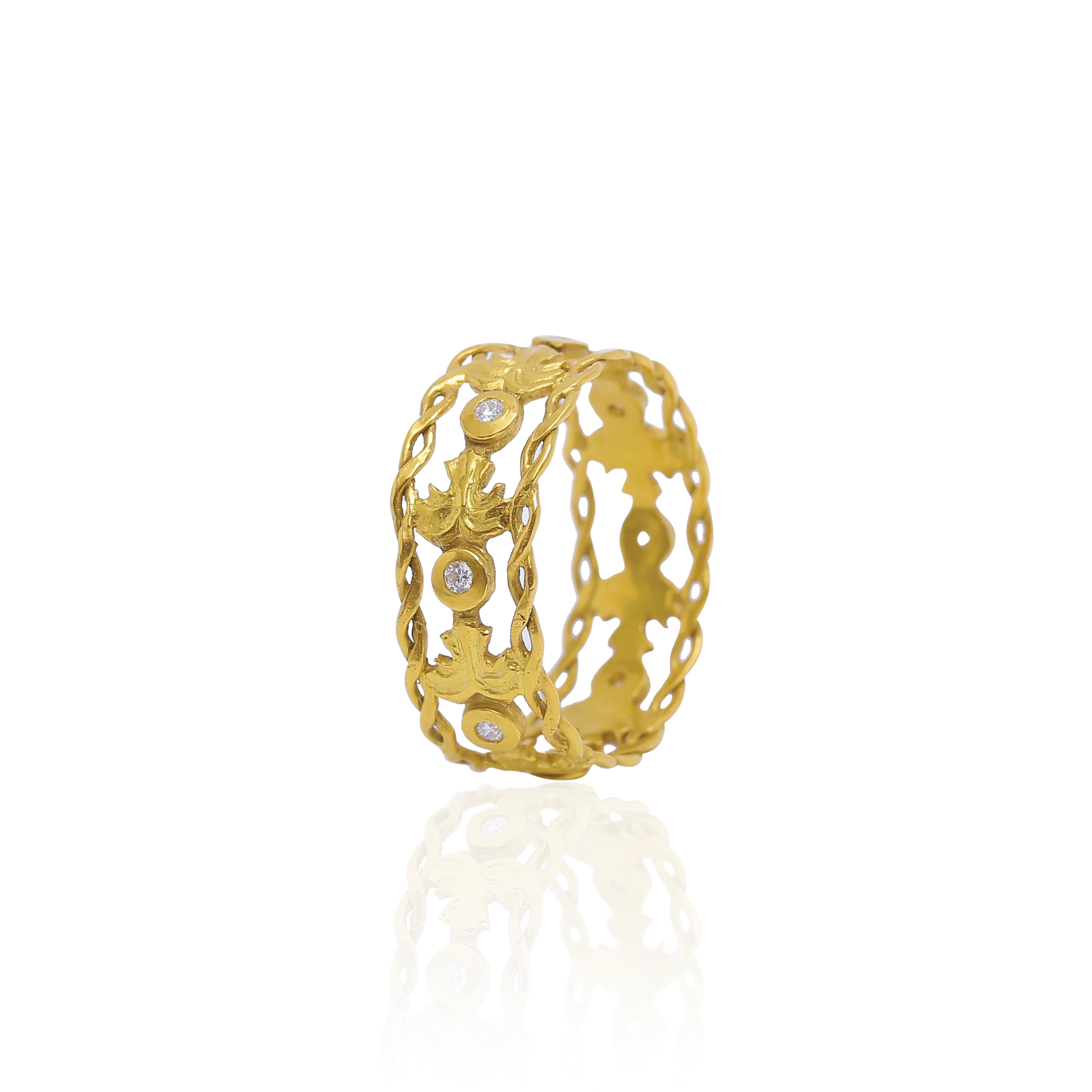 Gold ring with intricate design and embedded stones on a white background