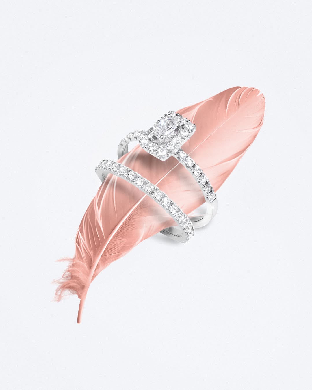 Diamond ring on a pink feather against a light gray background