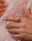 Model hand close up who is wearing beautiful vine gold ring with pearls