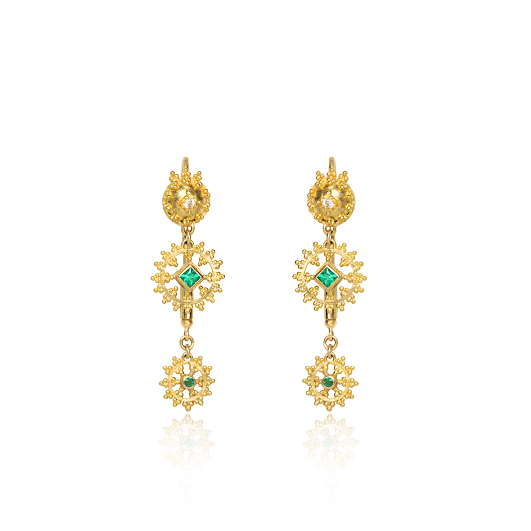 Gold earrings with green gemstones on a white background