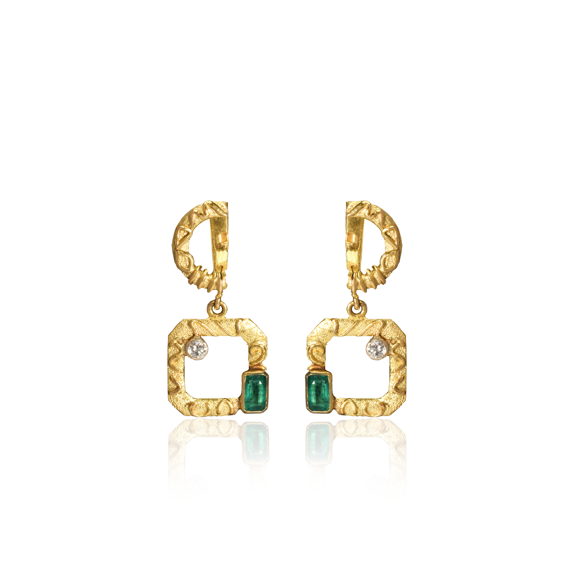 Gold earrings with green gemstones on a white background