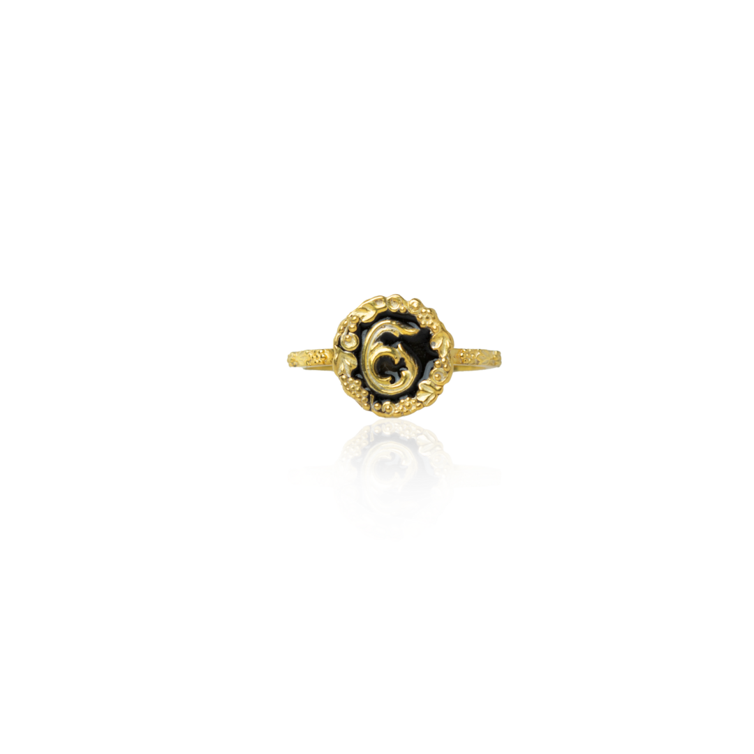 Gold ring with a black gemstone on a white background