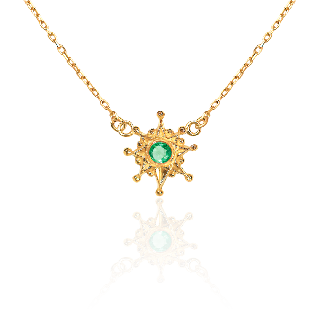 Gold necklace with a green gemstone pendant on a white background