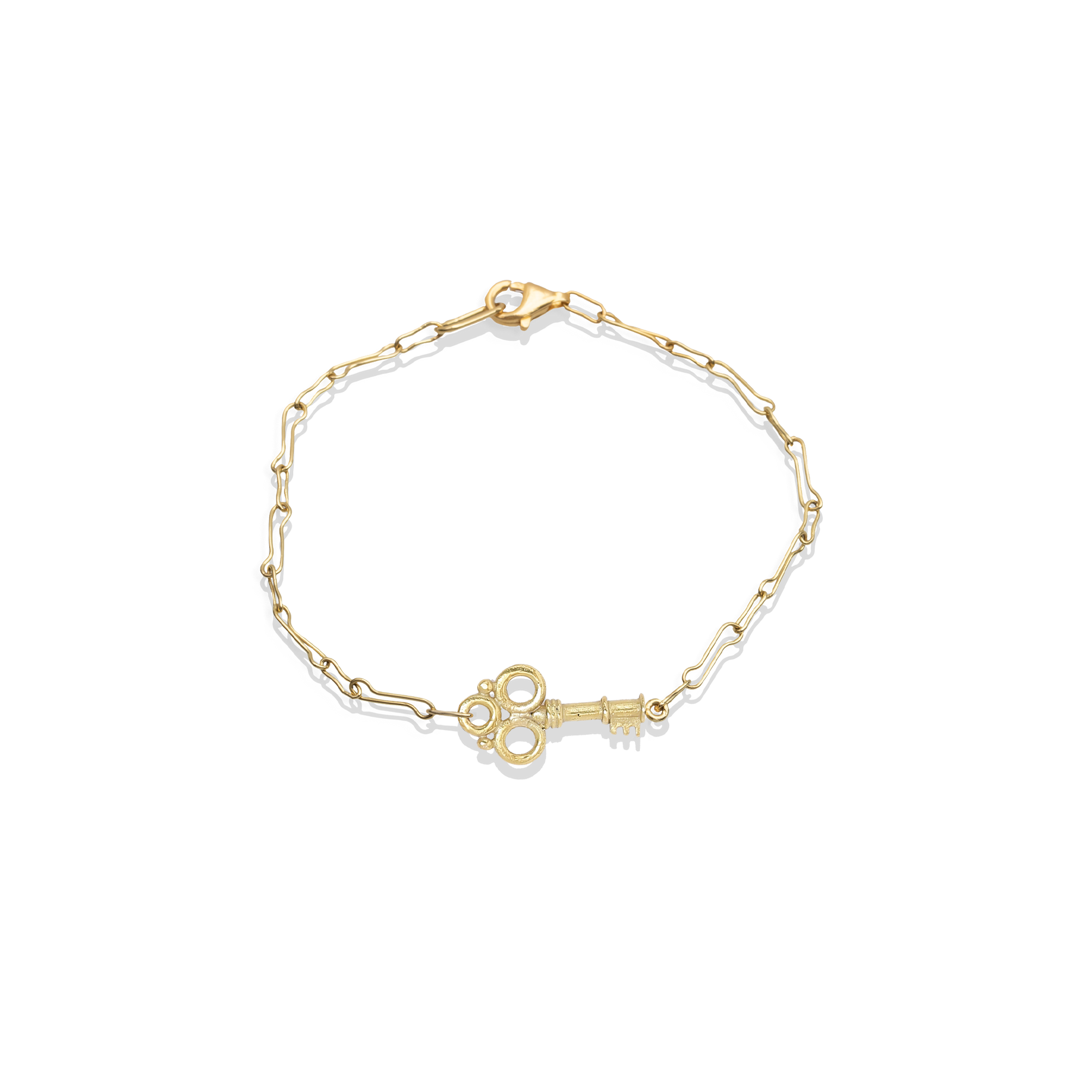 Gold bracelet with a key charm on a white background