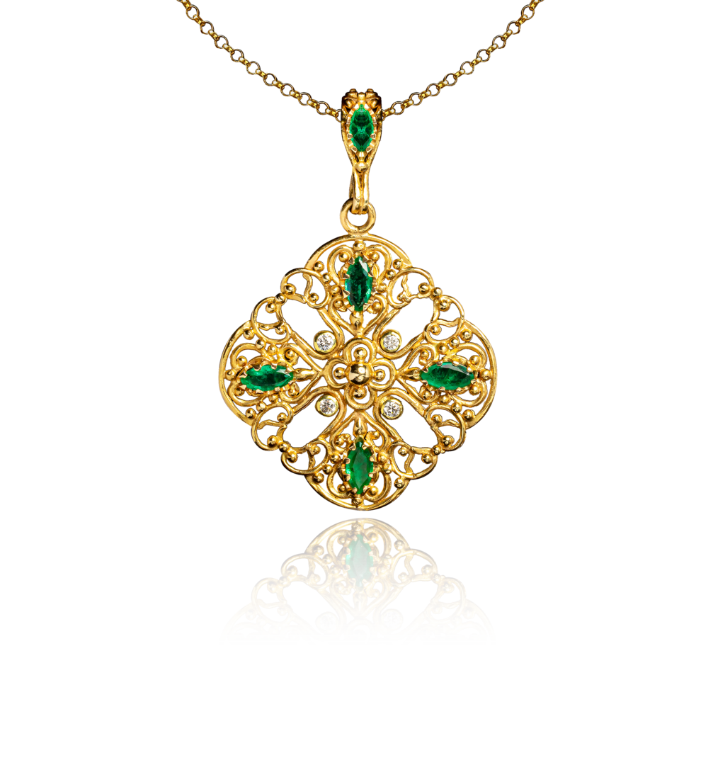ornate gold pendant with emeralds, diamonds, and intricate openwork filigree design