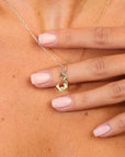 Gold necklace with a pendant on a person's chest