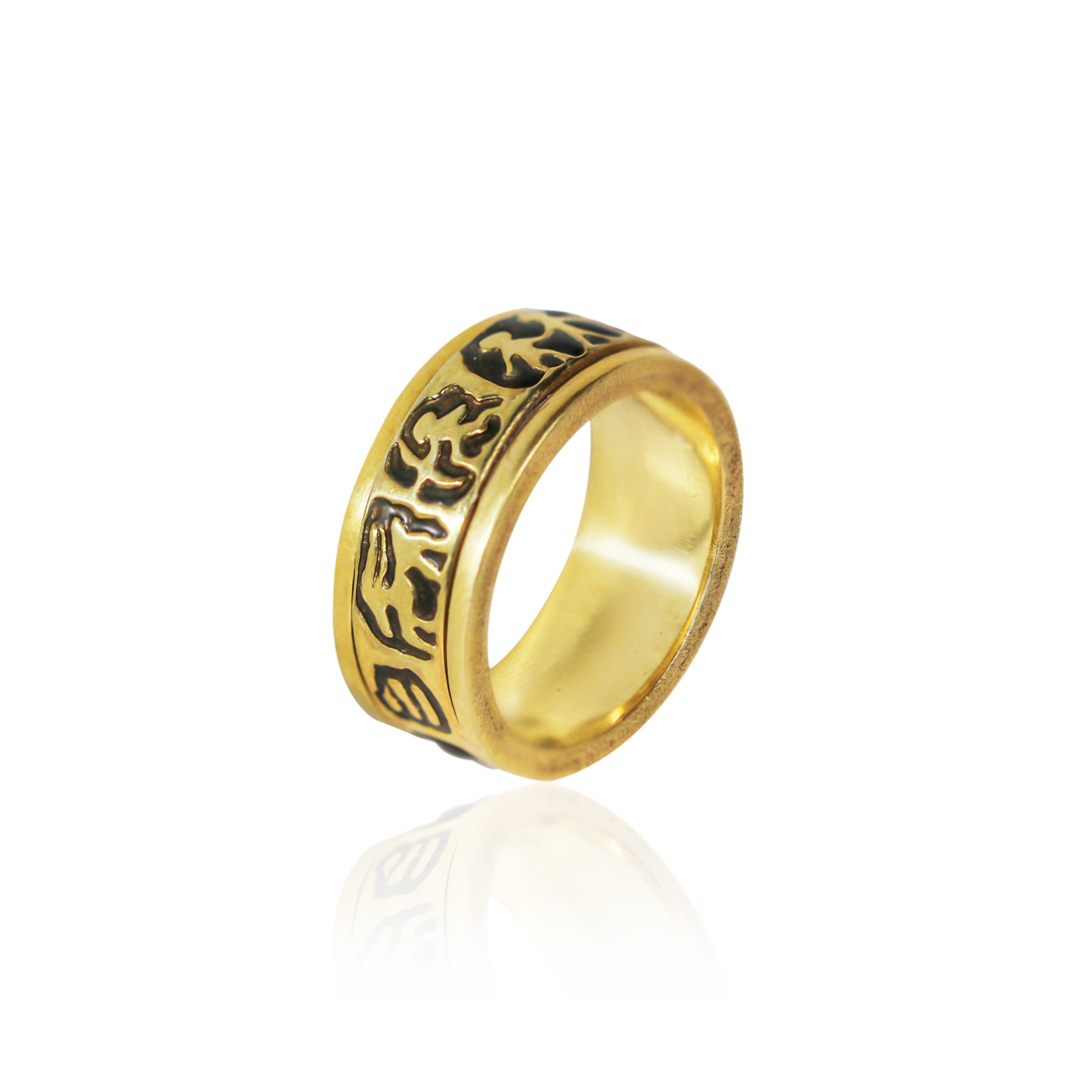 Gold ring with black engraved design on a white background