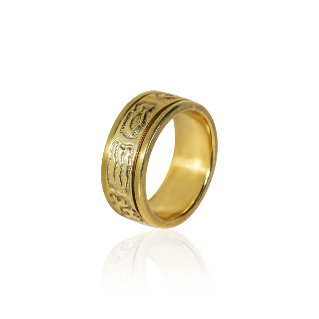 Gold ring with intricate designs on a white background