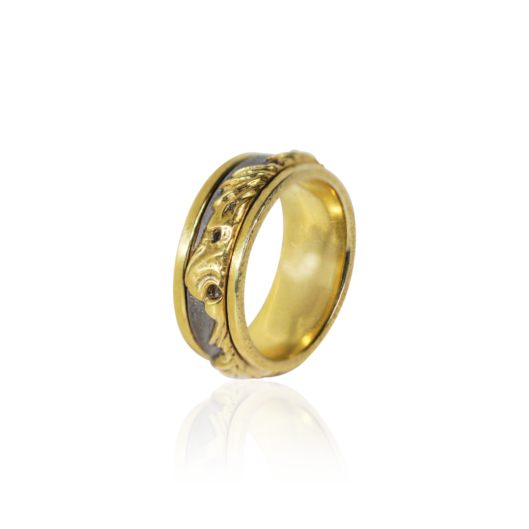 Gold ring with intricate design on a white background