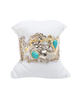Decorative bracelet with turquoise stones on a white stand