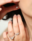 Close-up of a hand wearing two diamond rings with a blurred background