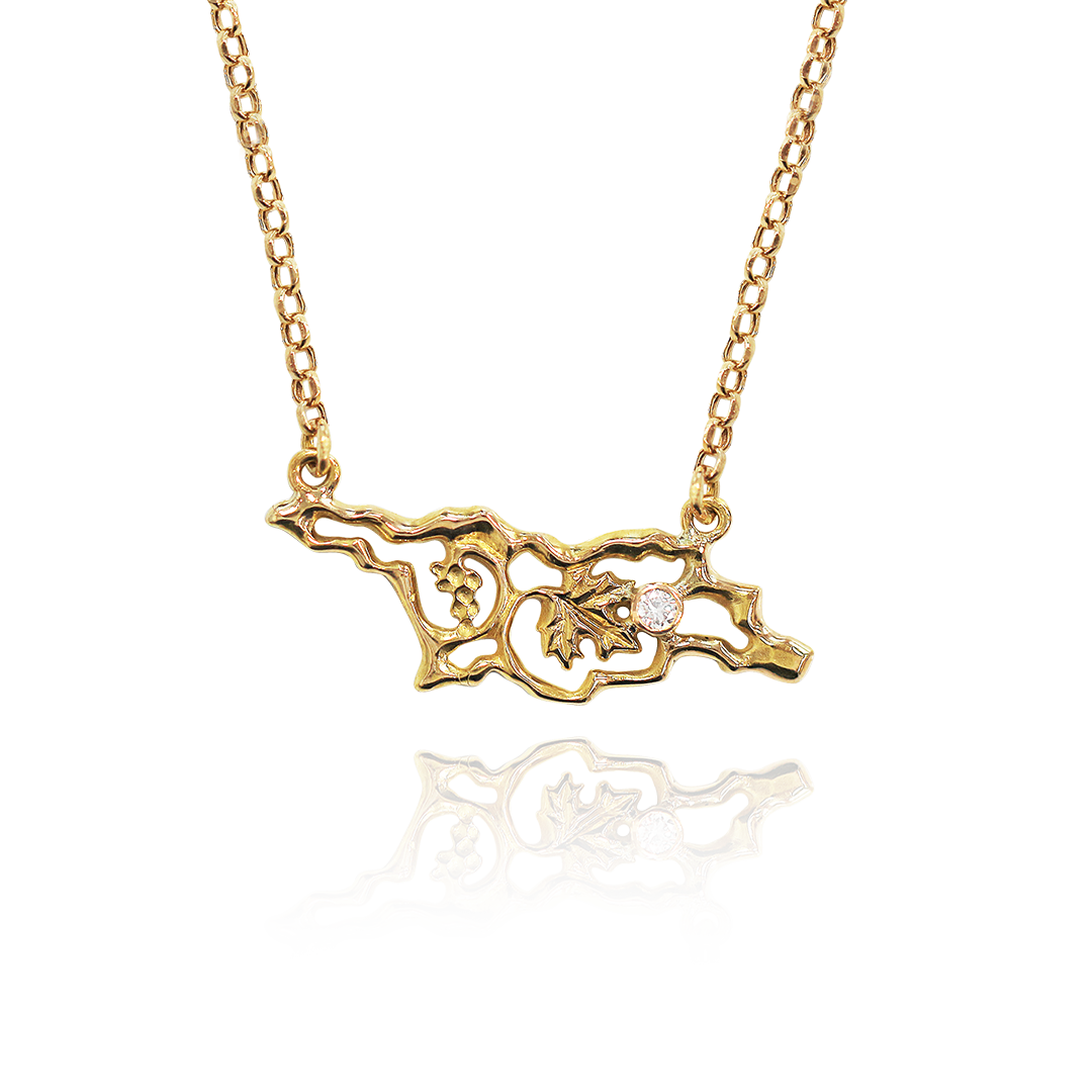 Gold necklace with a detailed pendant on a white background