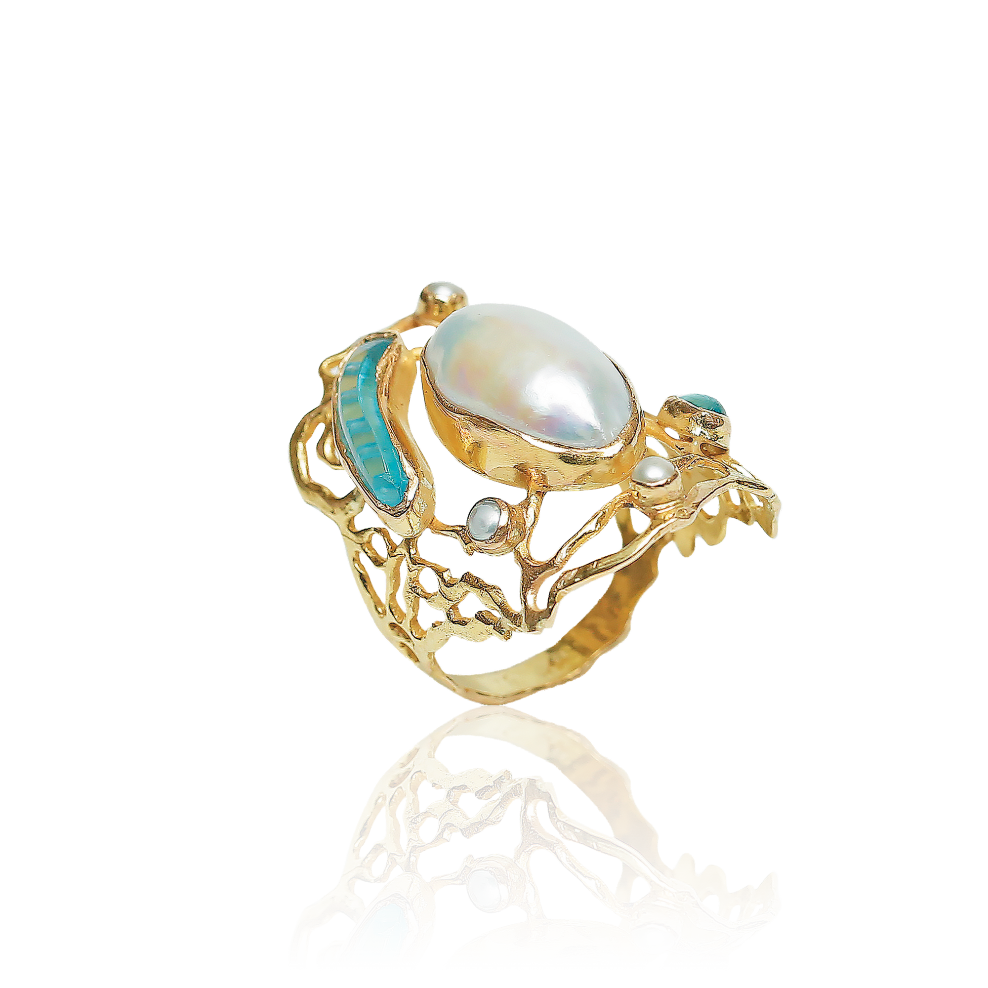 Gold ring with a large pearl and smaller gemstones on a white background