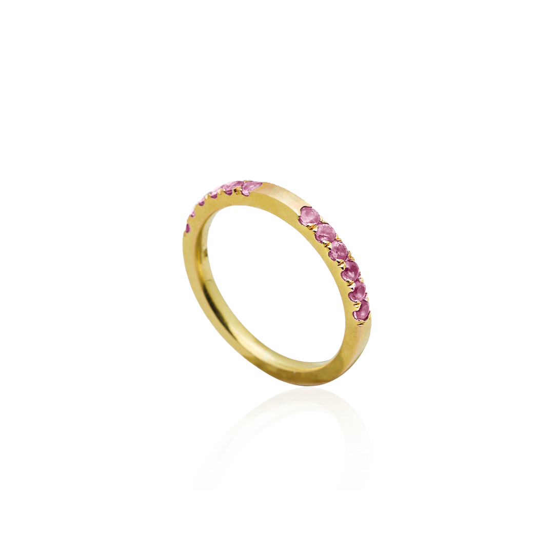 Gold ring with pink gemstones on a white background
