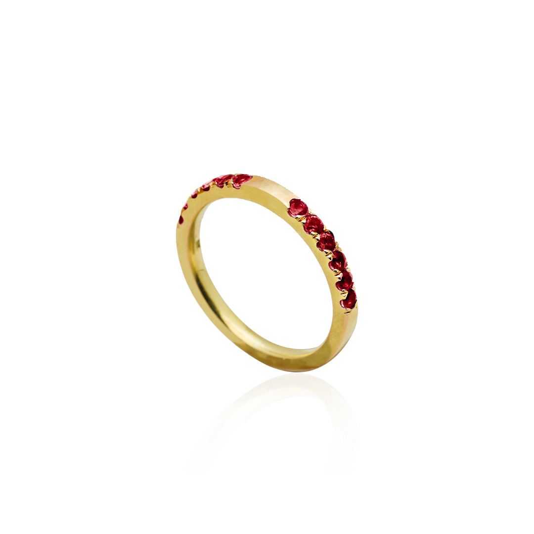 Gold ring with red gemstones on a white background