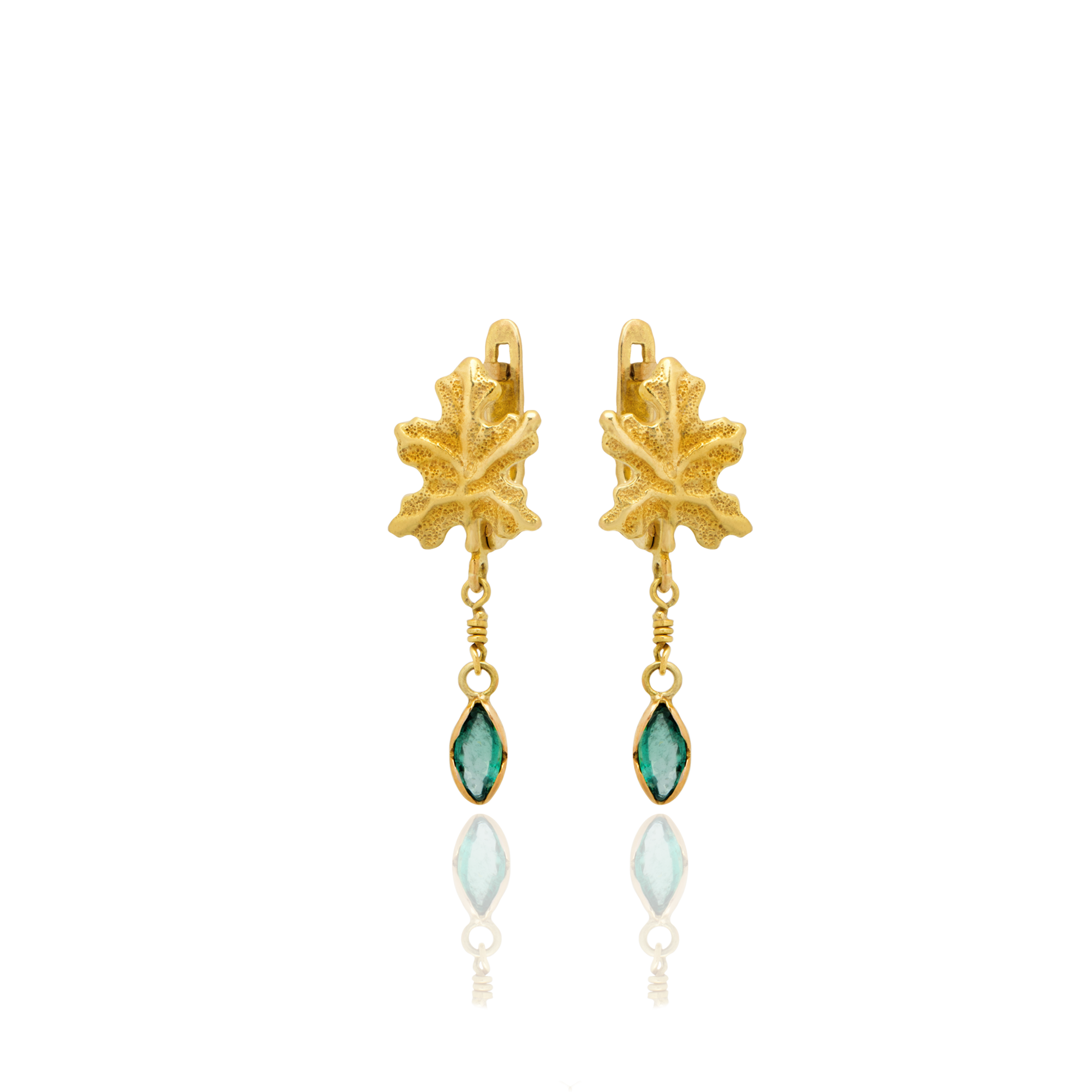 Gold leaf earrings with green and white gemstones on a white background