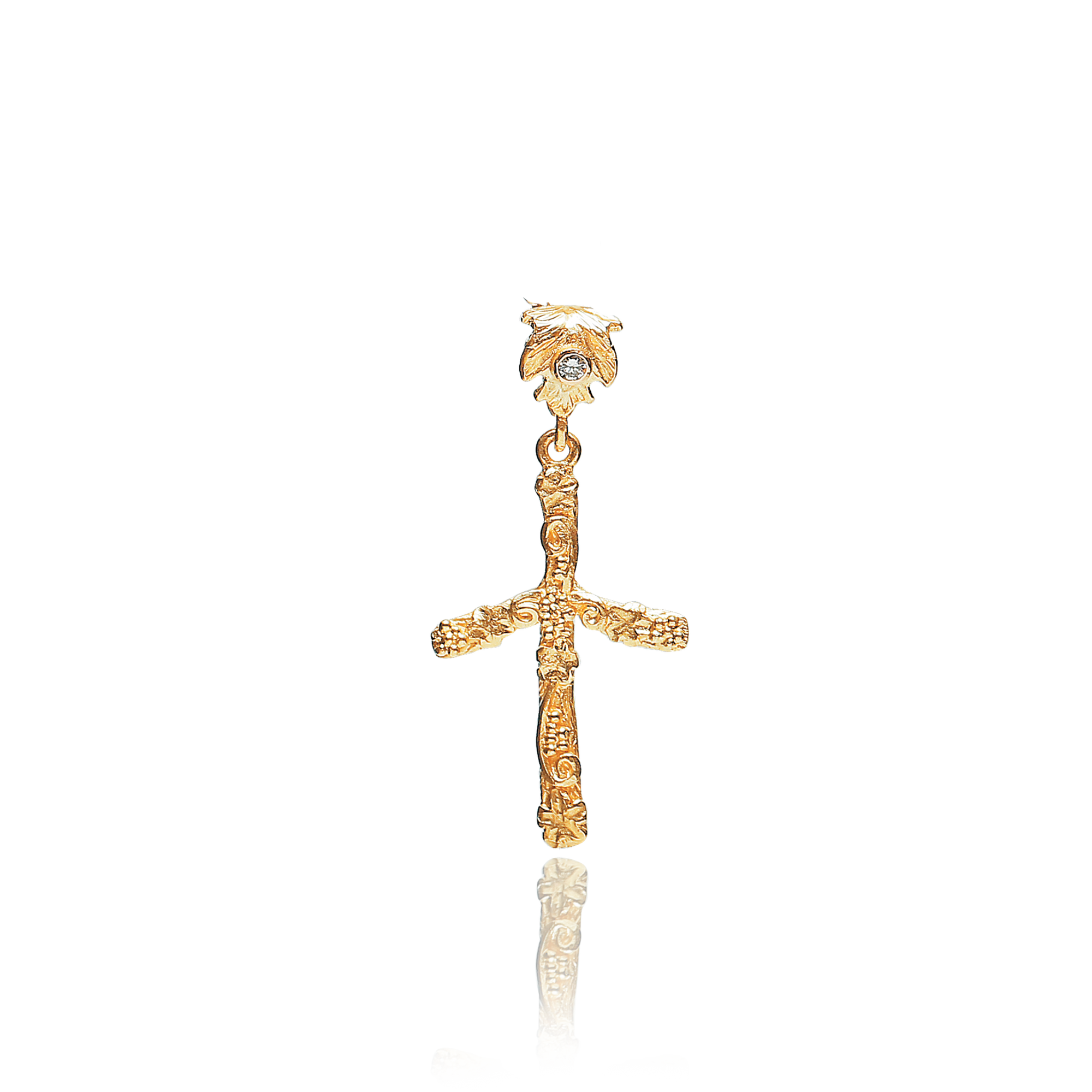 Gold cross pendant with a small gemstone on a white background