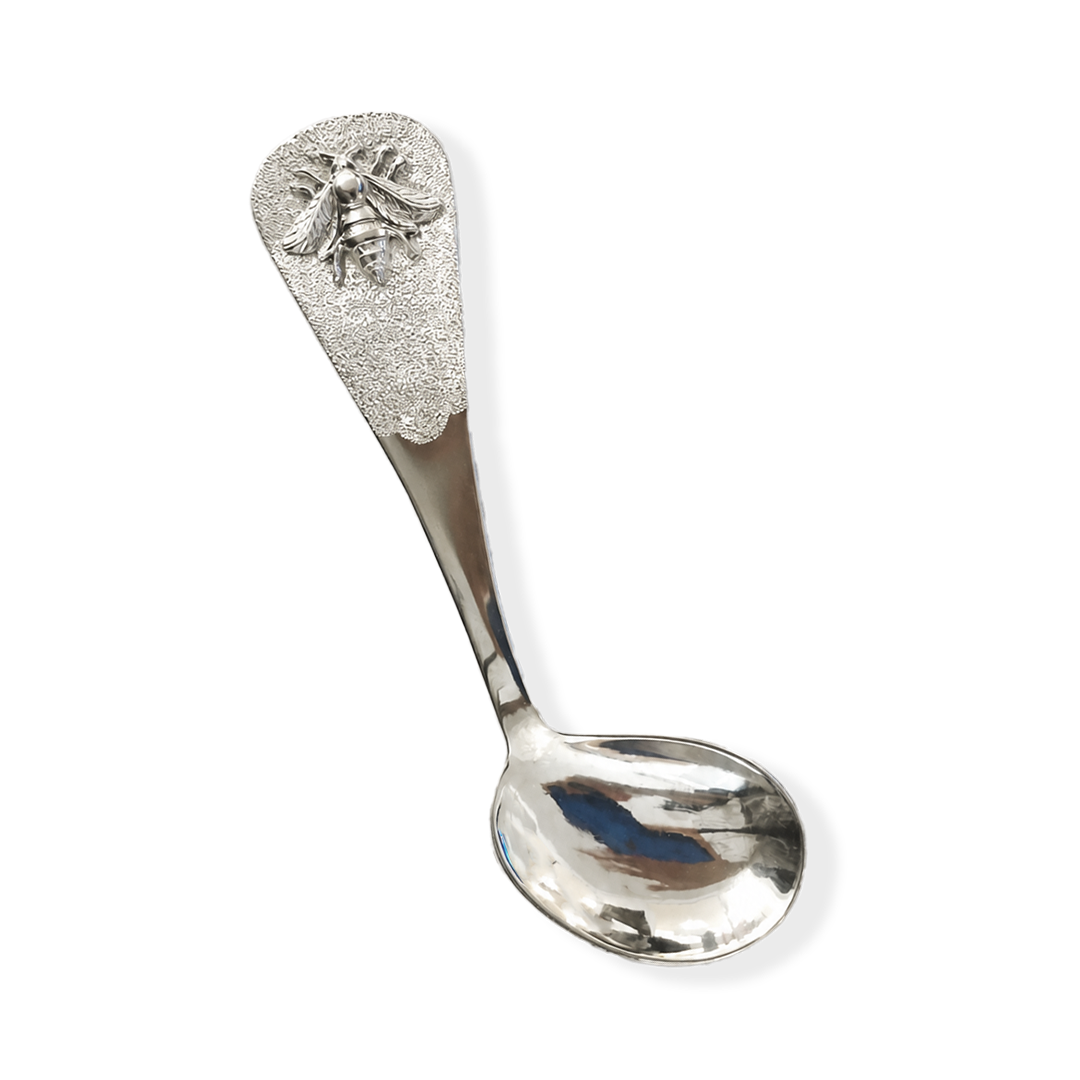 Silver spoon with decorative head on a white background