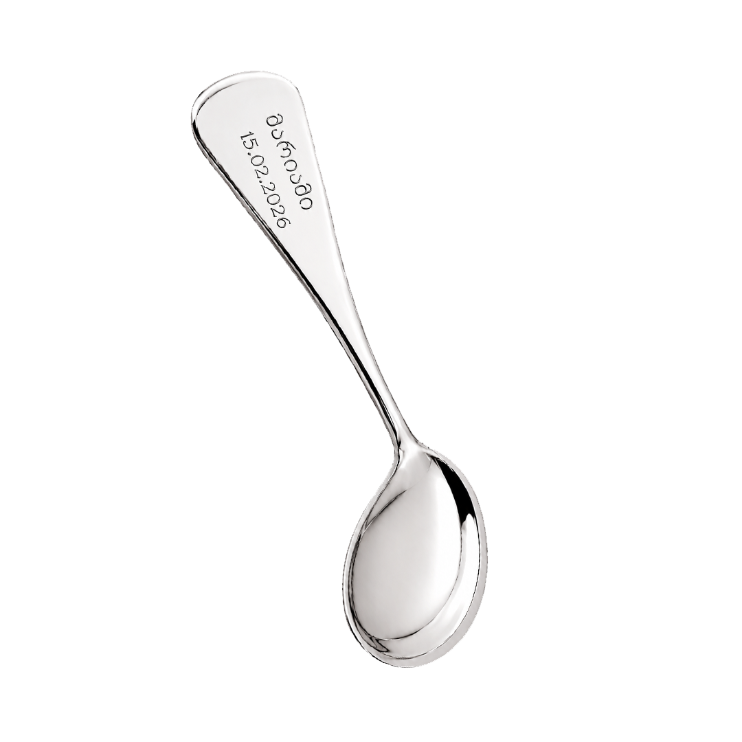 Silver spoon with engraved text on a white background