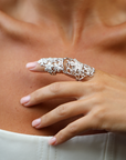Silver armor ring on a person's finger against a neutral background