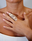 Close-up of a hand wearing a decorative ring on a blurred background