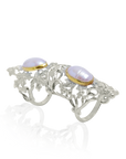 Silver armor ring with gold accents and two pearls on a white background