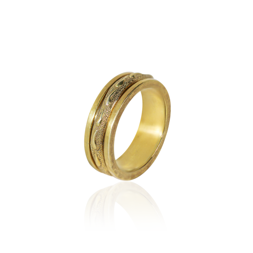 Gold ring with intricate design on a white background