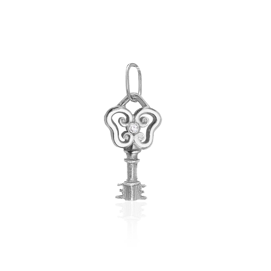 Silver key-shaped pendant with decorative elements on a white background