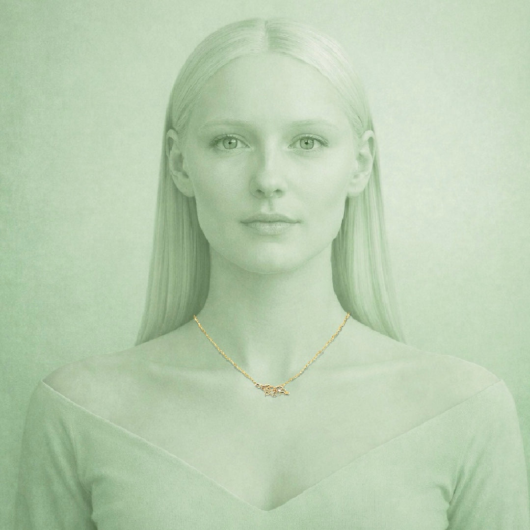 Woman wearing a gold necklace with a nameplate against a light green background